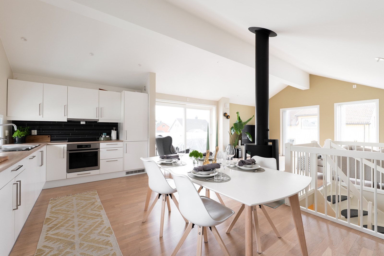 Andre etasje er en eneste stor sosial sone. Her er stuen og kjøkkenet sømløst forbundet under den høye himlingen som gir en meget luftig romfølelse. Galleribilde