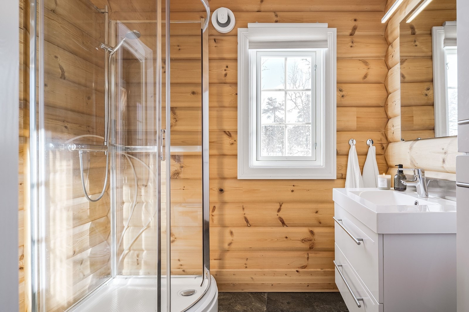 Hytta har et pent bad med fliser på gulv og gulvvarme. Galleribilde