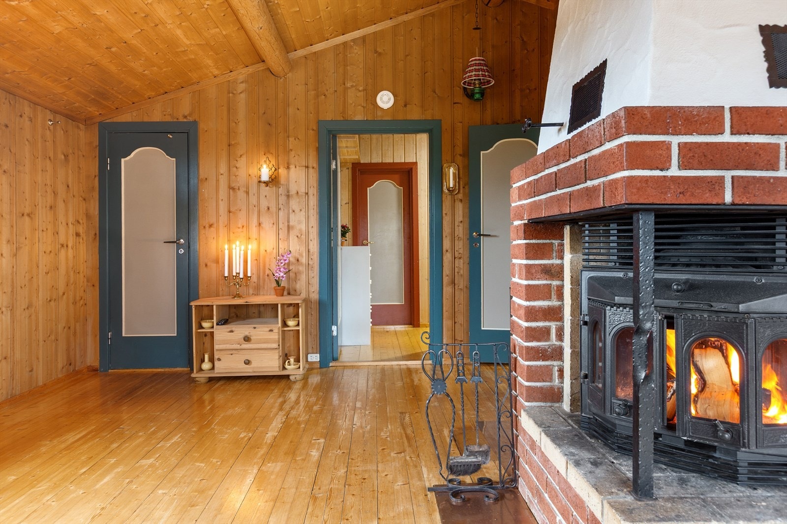 En peis med innsats strekker seg helt opp til himlingen, og gir flott innsyn til peisflammene. Galleribilde