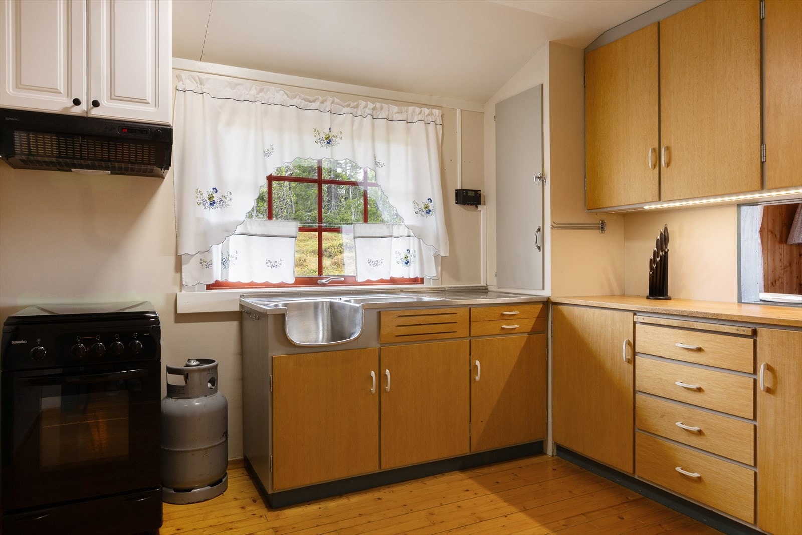 Innredningen har oppvaskbeslag av stål, komfyr med propandrift og ventilator med avtrekk ut. Galleribilde