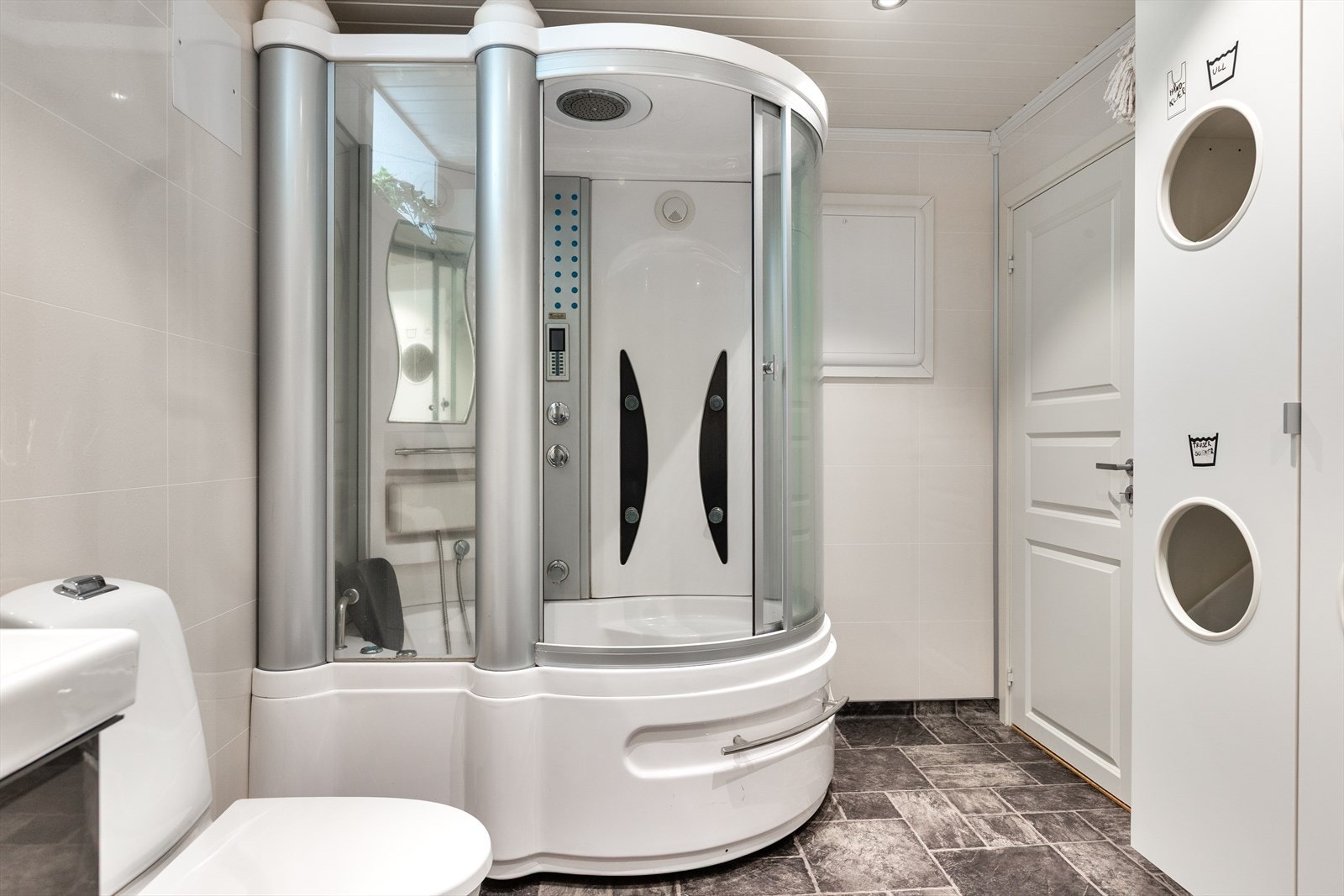 Som ren luksus har badet også stor stimdusj/boblebad som gjør dusjopplevelsen til en ekstra god opplevelse med et hint av spa. Vegghengt høyskap for skittentøy. Galleribilde