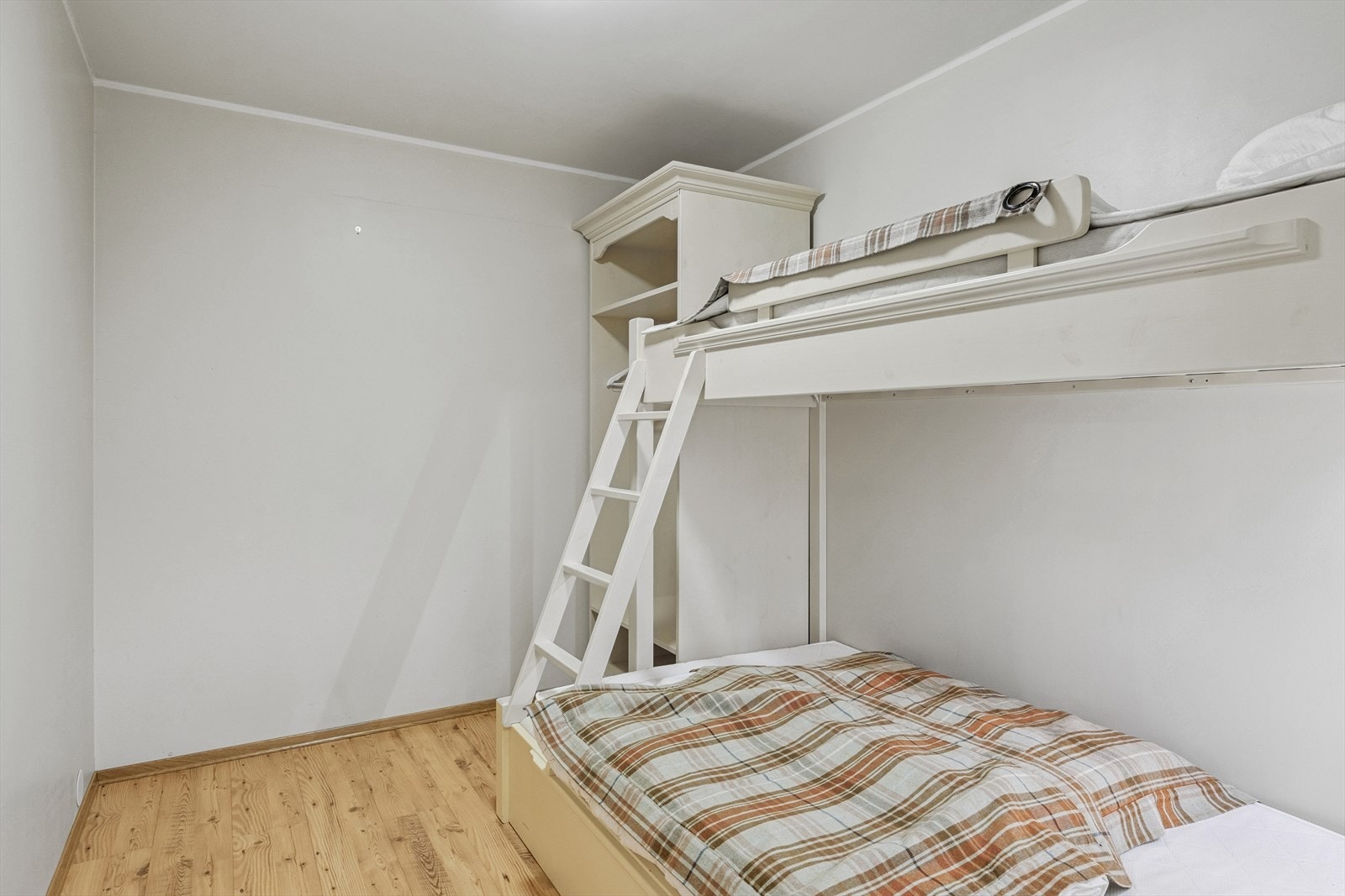 Det ene disponible rommet er innredet med praktisk familiekøye og garderobeskap for lagring av klær og sengetøy. Galleribilde