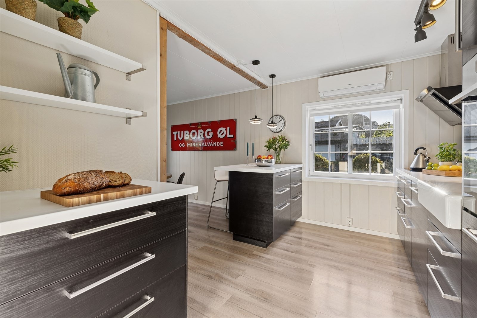 Kjøkkeninnredning fra IKEA (2016) med mørke, slette fronter og hvit laminert benkeplate med nedfelt oppvaskkum i hvit porselen. Galleribilde