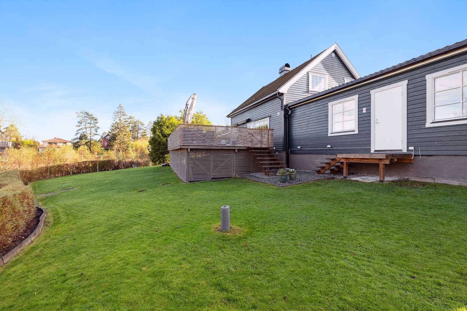 Stor hage som er pent opparbeidet med gressplen og hekk. Galleribilde