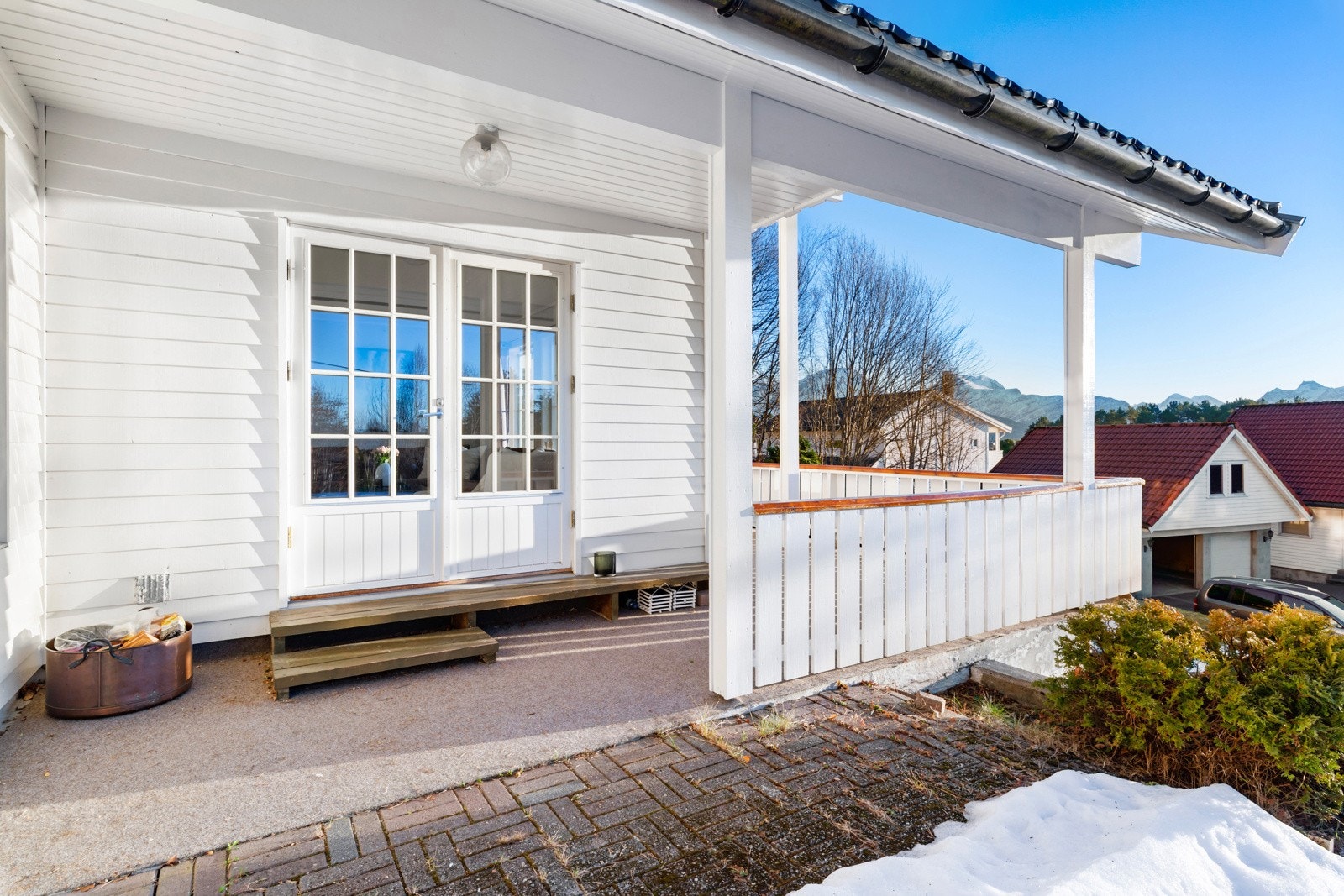 Verandaen mot sør er overbygd og går langs hele fronten av huset. Her er det bare å slenge beina på rekkverket og nyte de (få) soltimene vi har på Sunnmøre. Galleribilde