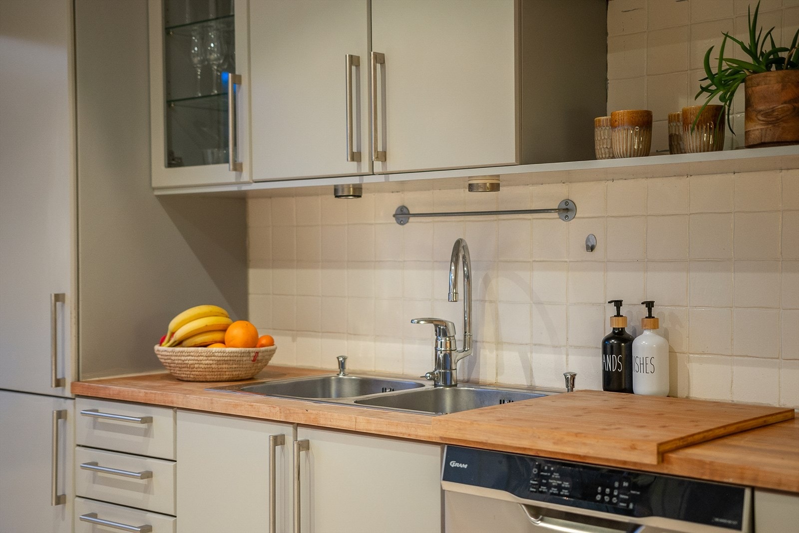 Kjøkkenfrontene er lakkert, noe som gir et mer moderne uttrykk. Kjøkkenet er utstyrt med kombiskap, oppvaskmaskin, platetopp, stekeovn og ventilator. Galleribilde