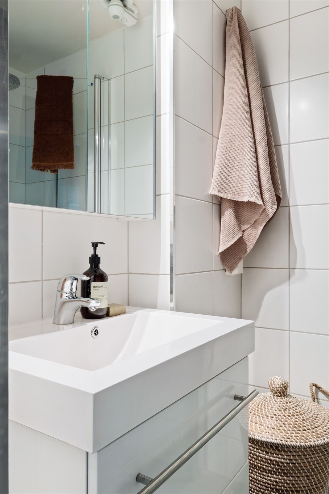 Vegghengt servantskap med ovenpåliggende servant, ett-greps armatur fra Hansgrohe og speilskap med belysning. Galleribilde