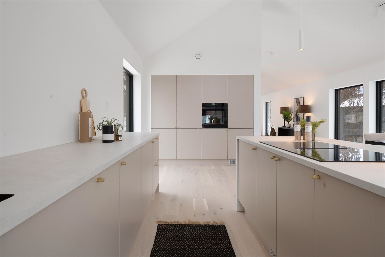 Velutstyrt kjøkken med helintegrerte hvitevarer. Induksjonstoppen har integrert ventilator i benk Galleribilde