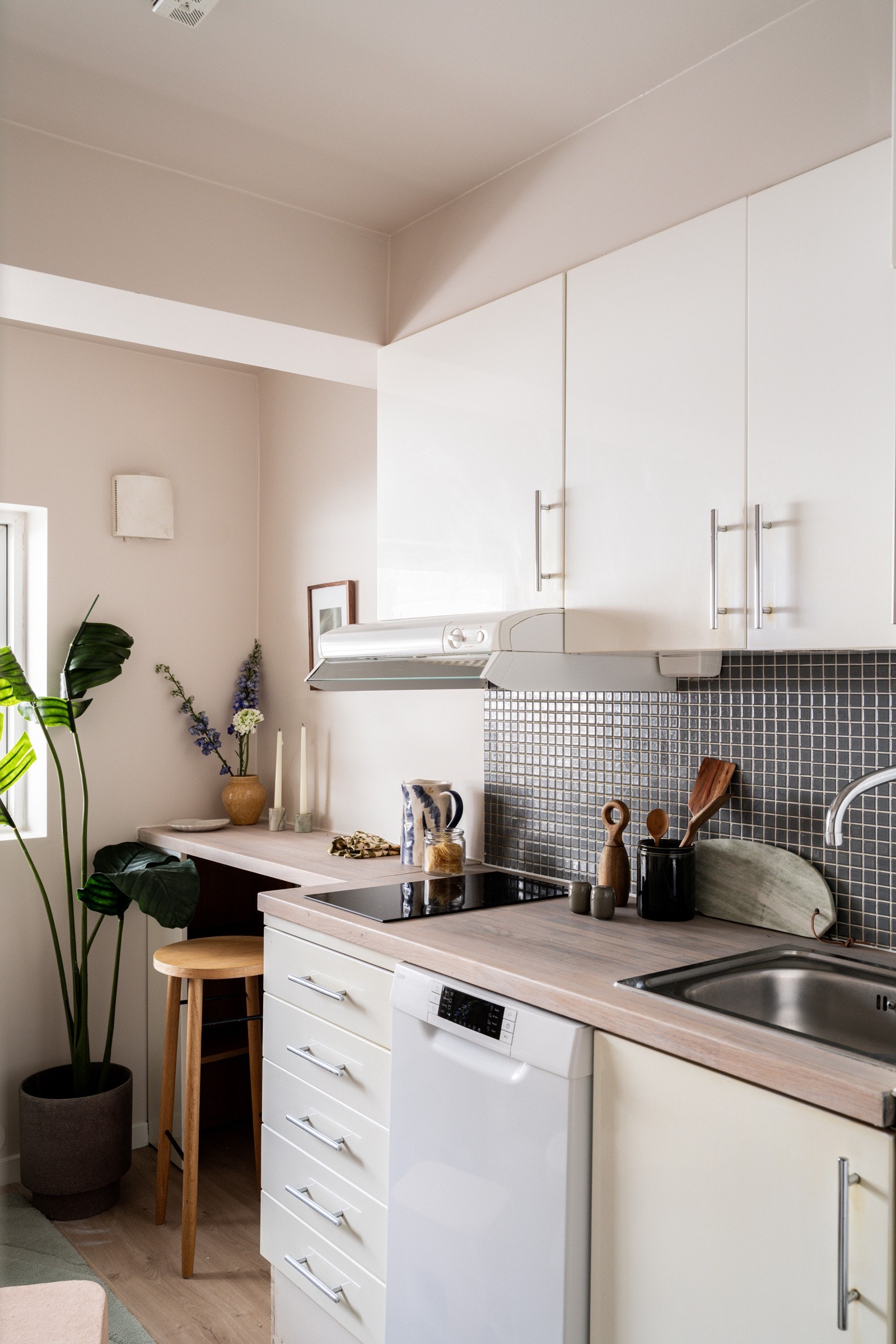 Lys og pen kjøkkeninnredning fra 2008 med hvite glatte fronter og lys heltre benkeplate med nedfelt oppvaskkum. Galleribilde