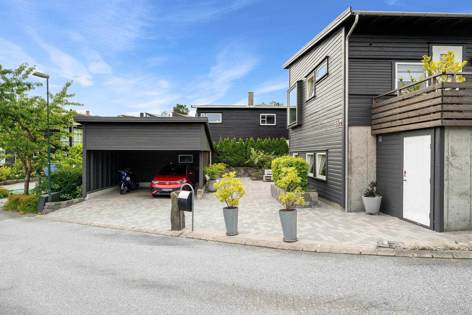 I et steinlagt gårdsrom har boligen en dobbel carport med innlagt strøm og tilknyttet bod på ca. 13 kvm. Galleribilde