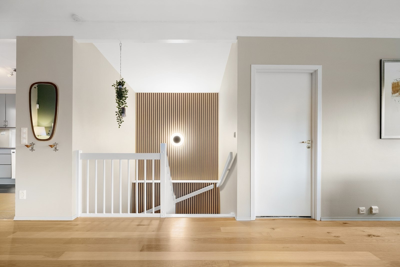 Innslag av trendy spiler går igjen i trappen, der endeveggen er kledd med spiler til taket. Galleribilde