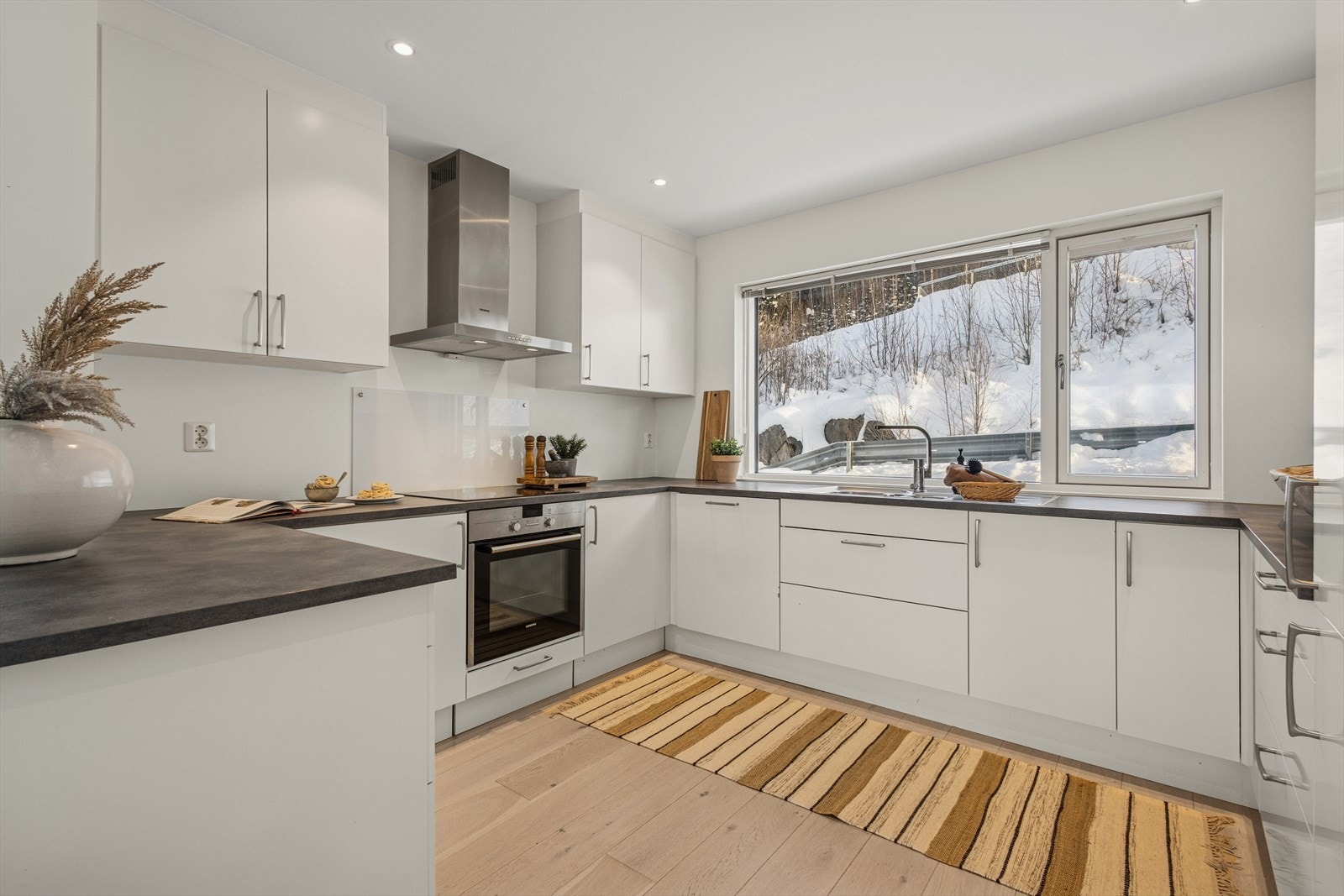 Kjøkkenet har en pen innredning med lyse fronter og laminert benkeplate. Galleribilde