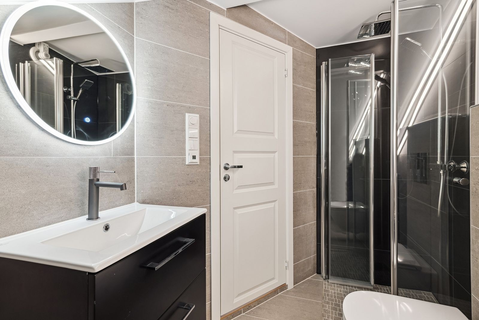 Nytt flislagt bad med vegghent toalett, hjørnedusj, servant m/innredning og lysspeil. Galleribilde