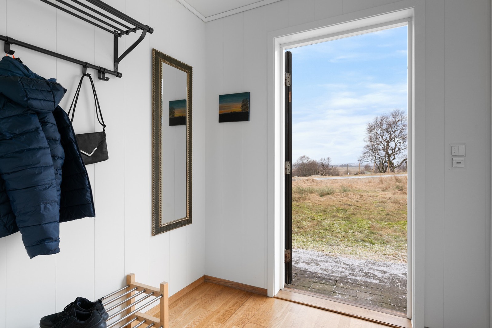 Entreen har parkett på gulv og lysmalte veggflater. Rommet har god plass til oppheng av yttertøy og sko. Galleribilde