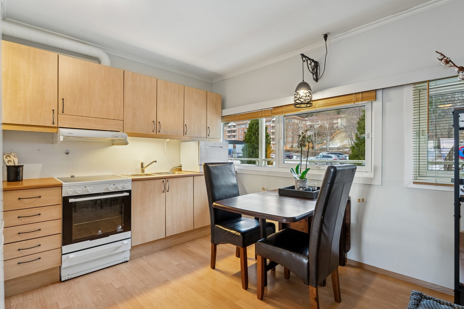 Kjøkkenet er utstyrt med frittstående komfyr, kjøl-/fryseskap og en oppvaskmaskin som er plassert på benken. Galleribilde