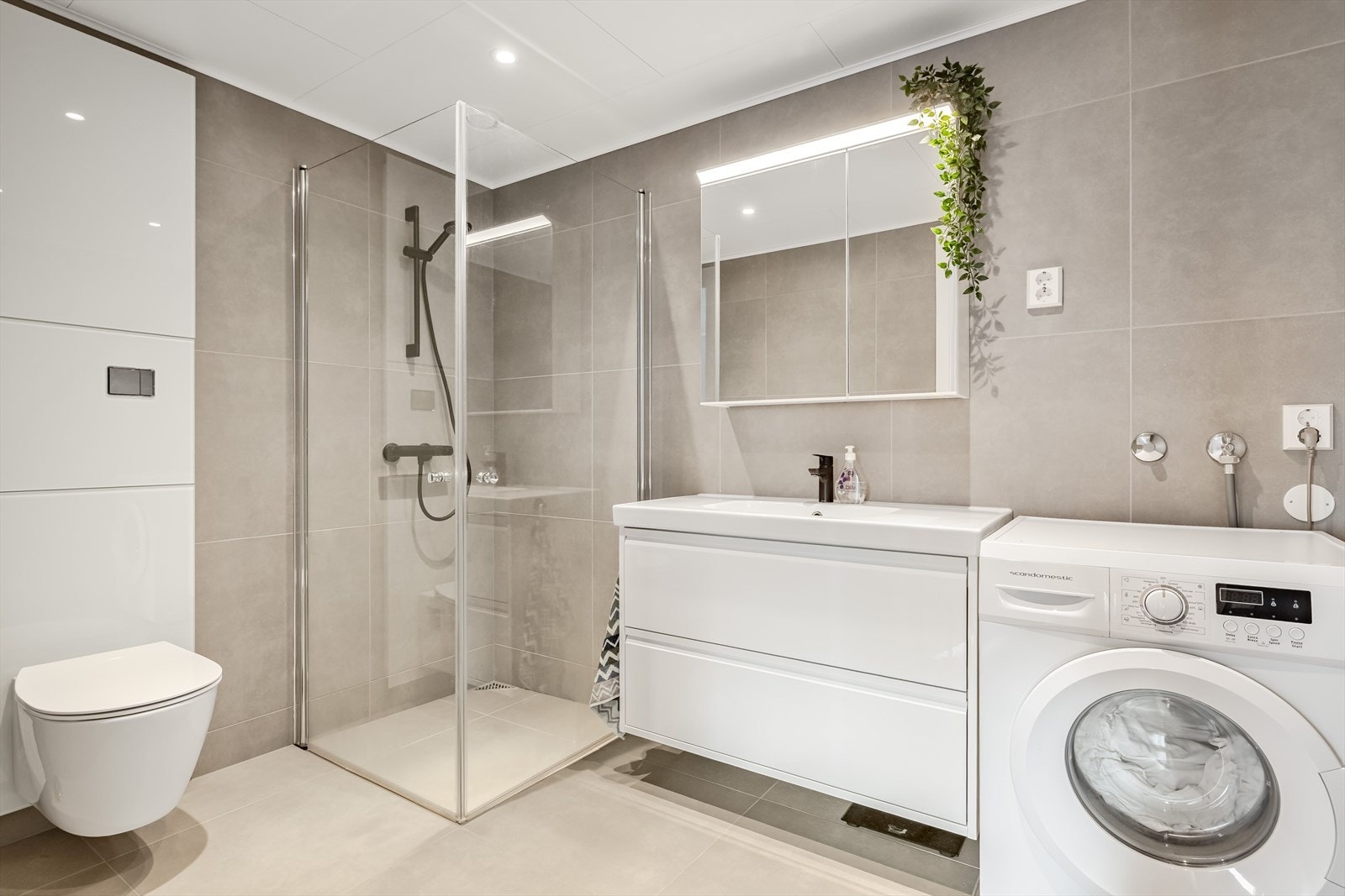 Romslig bad med flislagte vegger og gulv. I gulvet er det elektriske varmekabler. Galleribilde