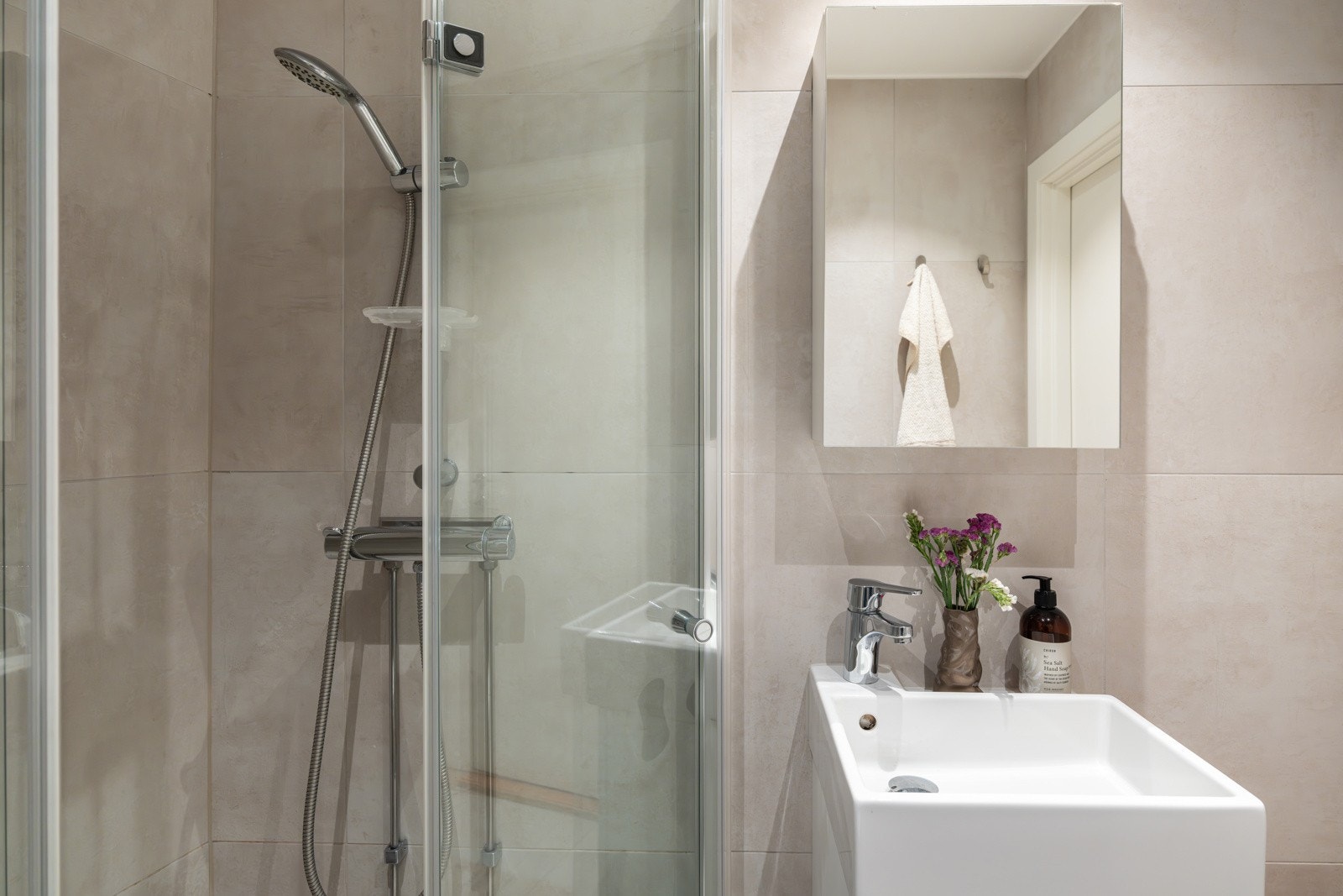 Baderommet er utstyrt med servantskap, speilskap, dusjhjørne med innfellbare glassdører og vegghengt toalett. Galleribilde