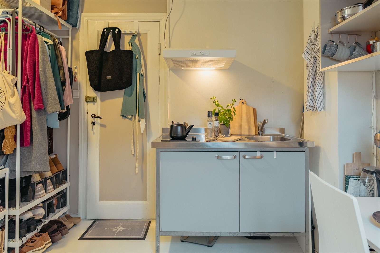 Praktisk lite hybel kjøkken med keramisk platetopp, minikjøleskap under vask og vifte Galleribilde