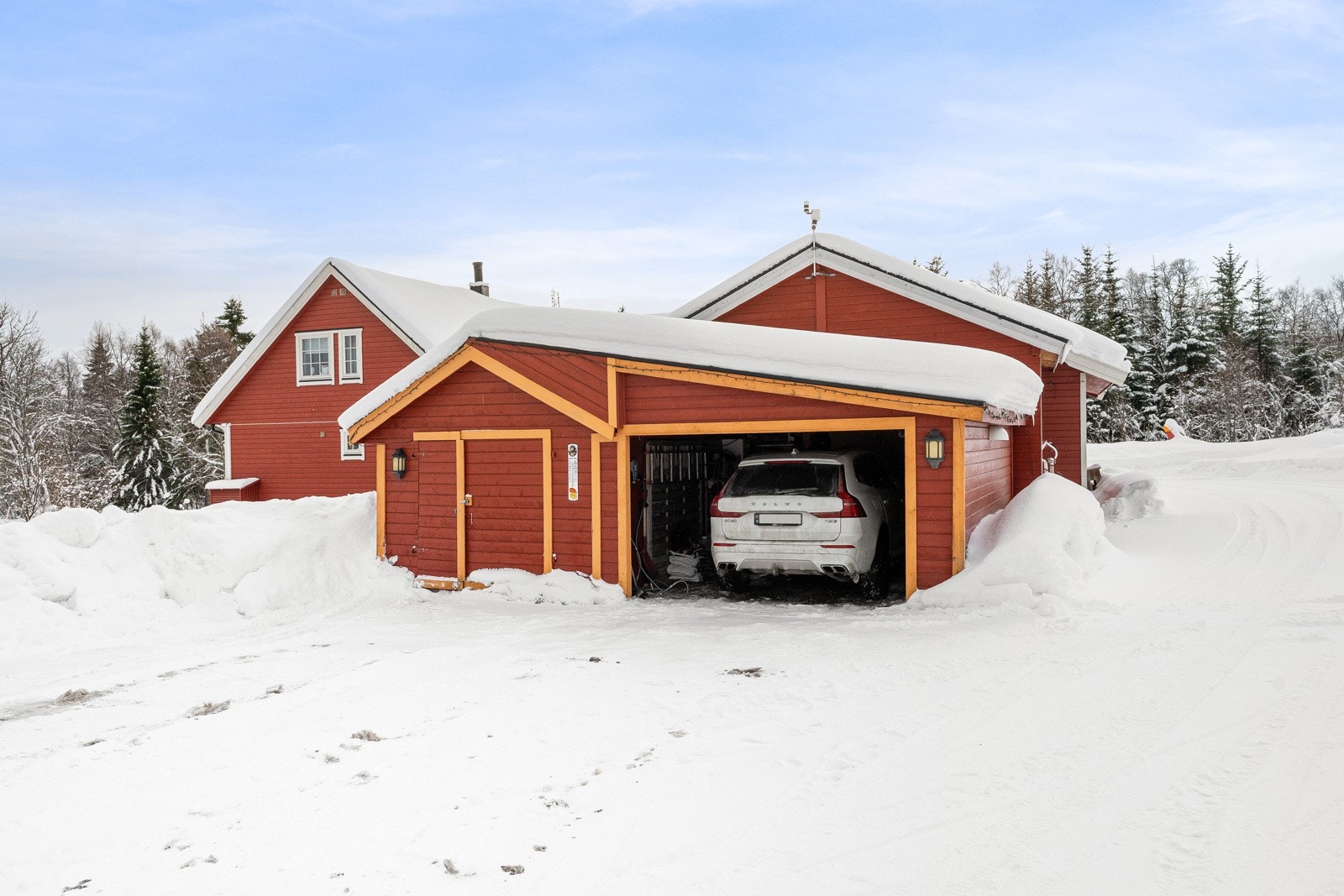 Boligen disponerer garasje med ekstra bodplass.