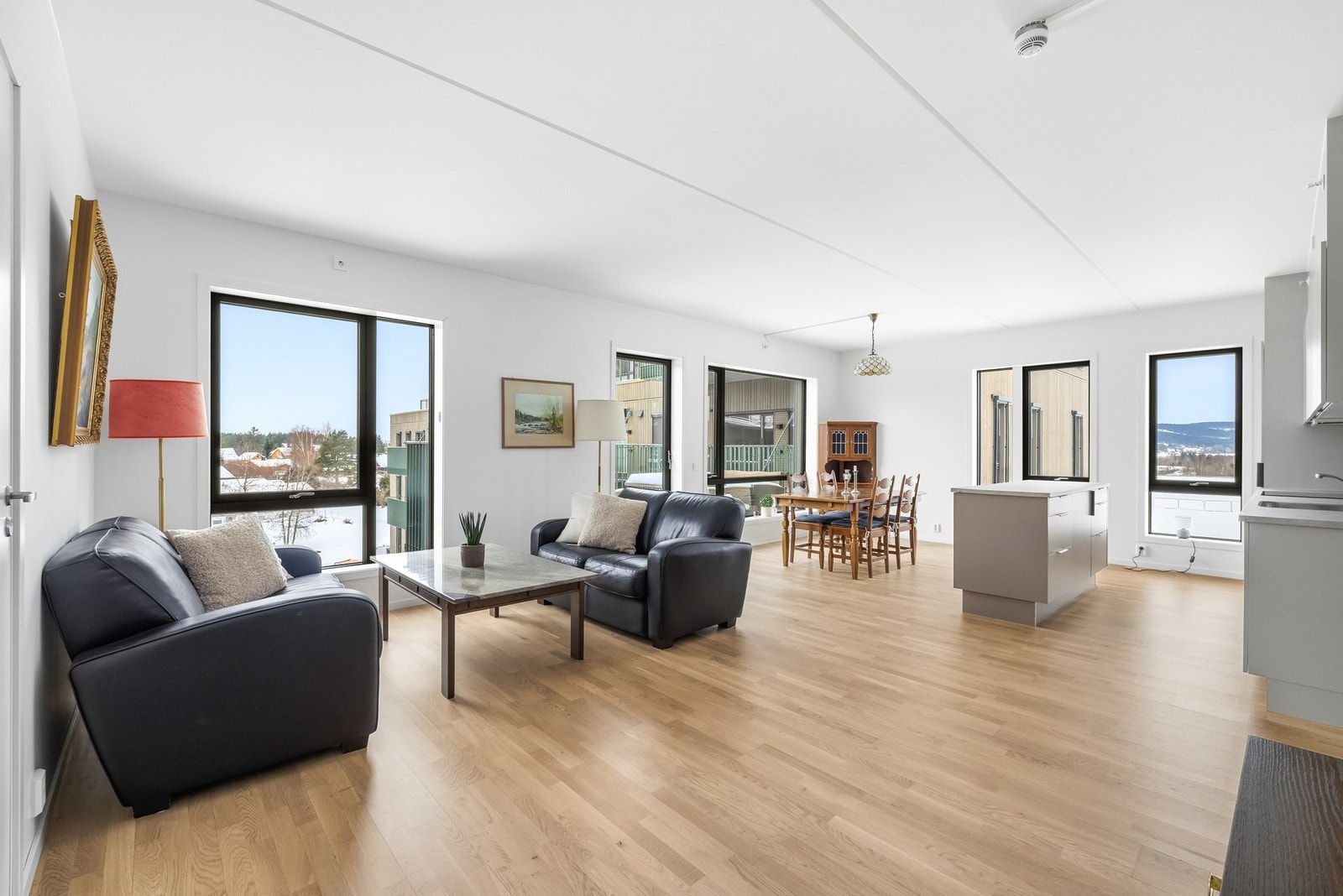 Stuen har slette hvitmalte vegger og samme trestavs parkett som er gjennomgående for leiligheten. Galleribilde