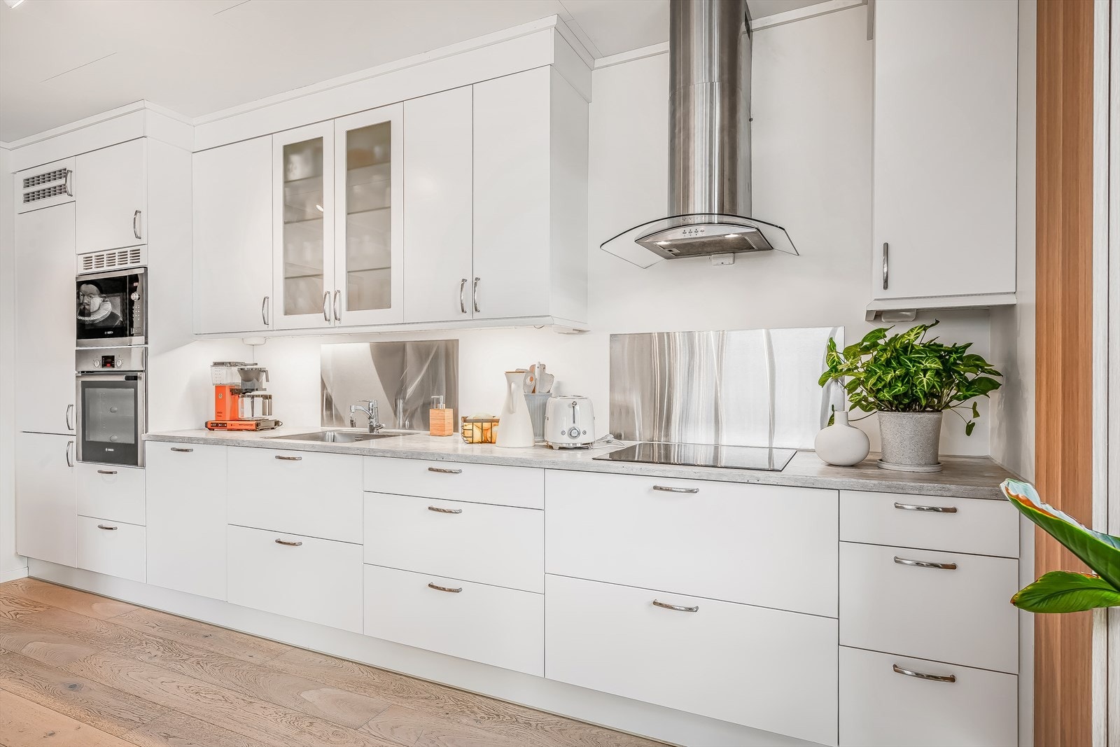 Lys og tidløs kjøkkeninnredning med glatte fronter. Kjøkkenet er utstyrt med
hvitevarer som kjøl/fryseskap, komfyr, platetopp, mikro og oppvaskmaskin. Galleribilde