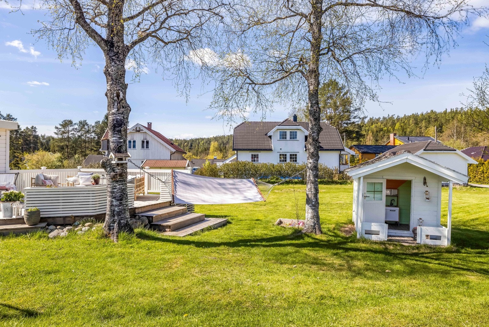På tomten står også et sjarmerende dukkehus til glede for de minste. Galleribilde