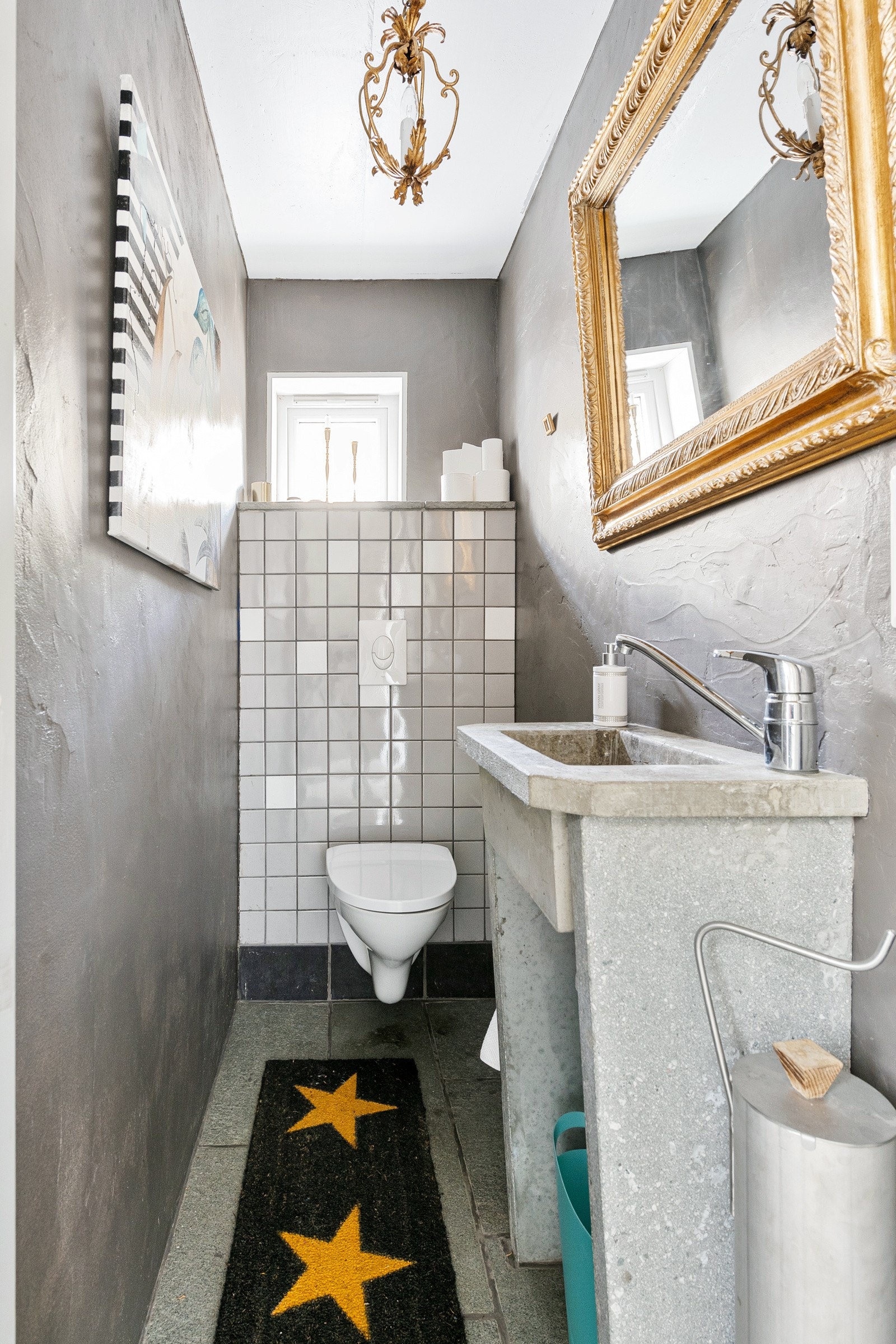 Toalettrommet har skiferflis på gulv med gulvvarme, med støpt vask og vegghengt toalett. Galleribilde