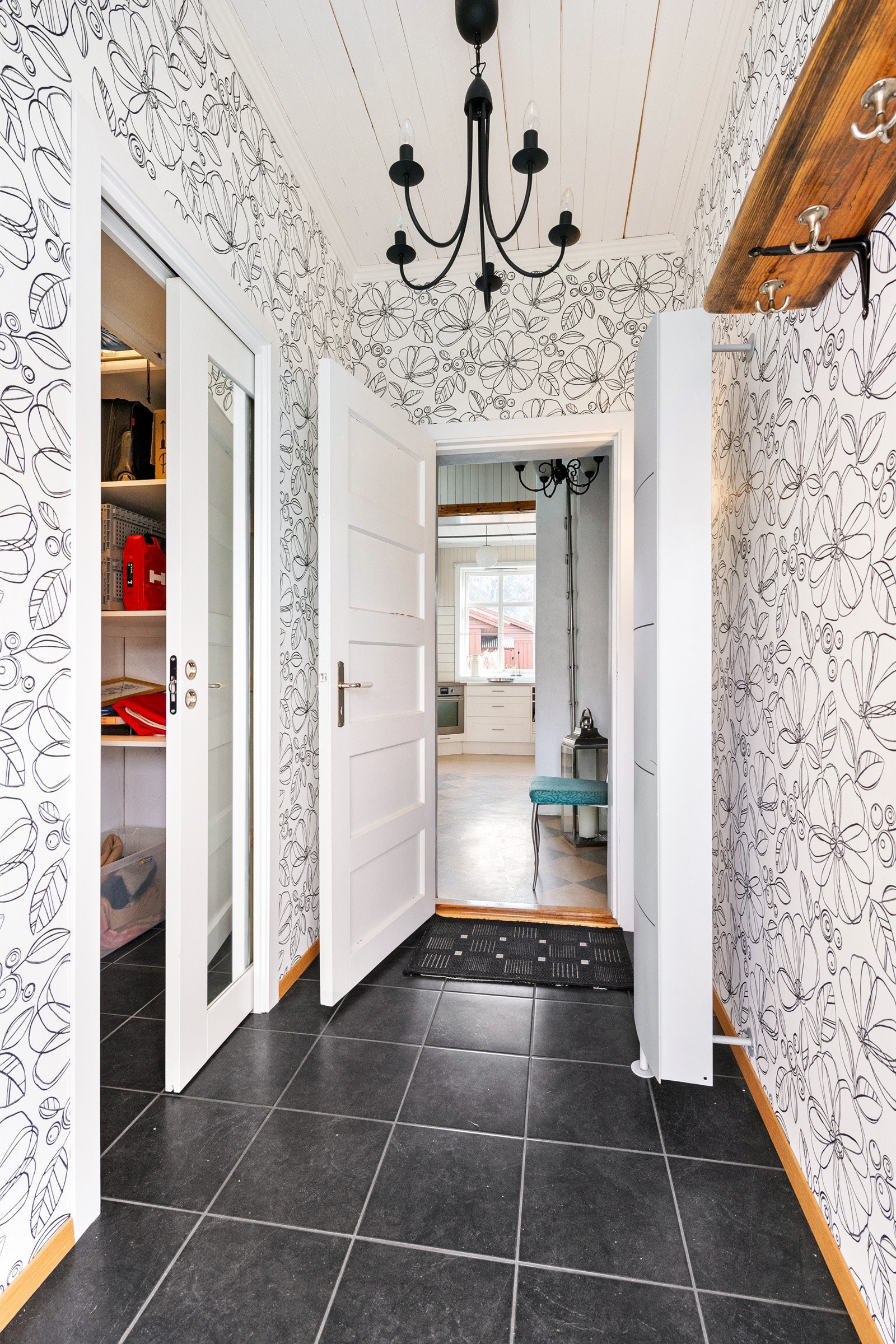 Det er to entréer til huset - her er den andre. Her kommer man inn i en lys gang med adkomst til et garderoberom og videre inn til trapperommet. Galleribilde