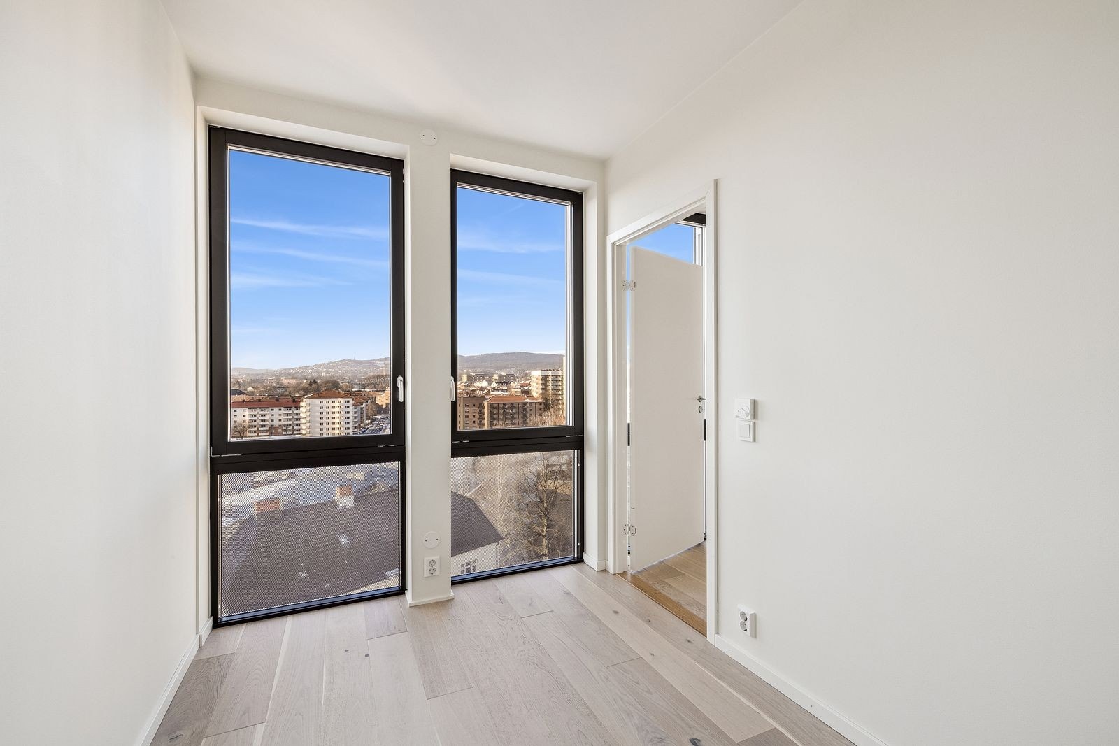 Lyst og romslig soverom med elektrisk solskjerming Galleribilde