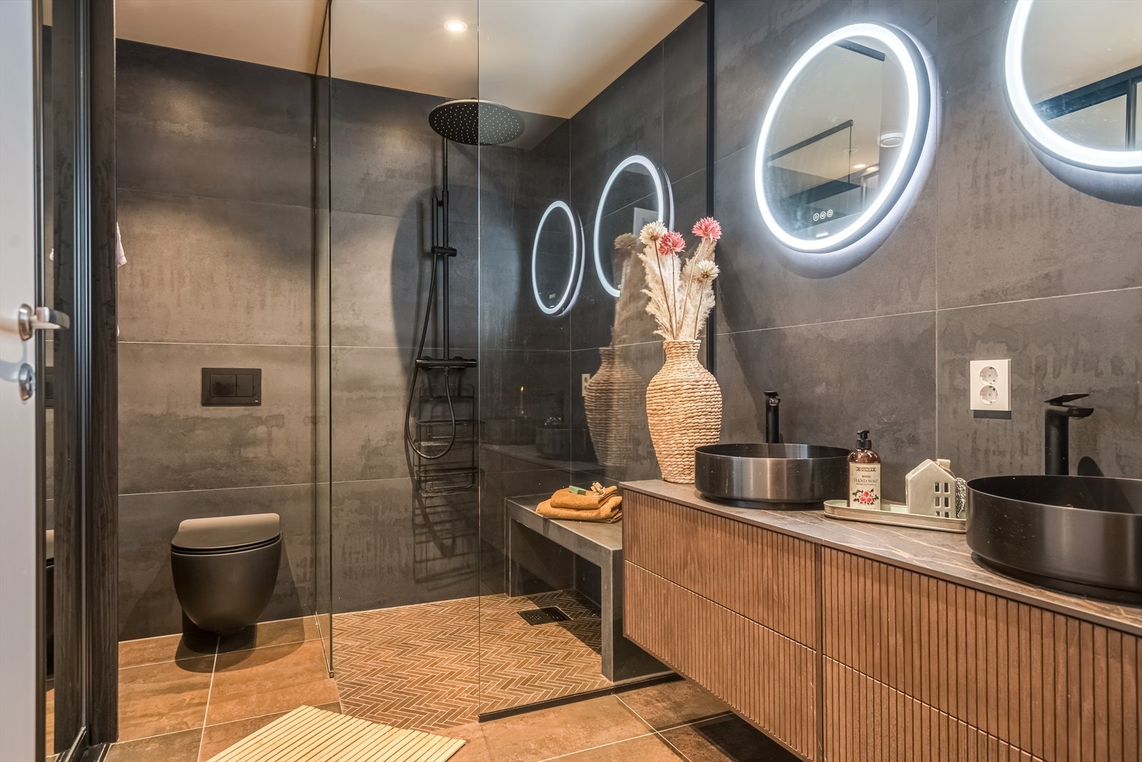 Flislagt bad med varmekabler, god romløsning og skjult teknisk anlegg i skyvedørsgarderobe. Rommet har servant, veggmontert toalett, dusjvegger/hjørne og opplegg for vaskemaskin. Galleribilde