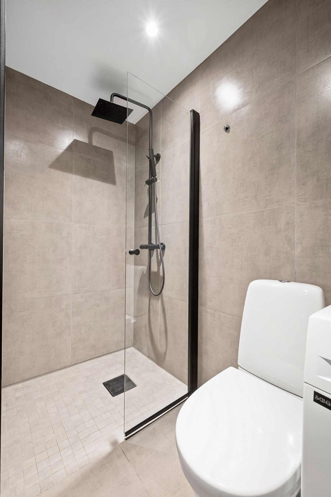 Badet byr på en romslig dusjnisje med både håndholdt dusj og regnfallsdusj. Galleribilde