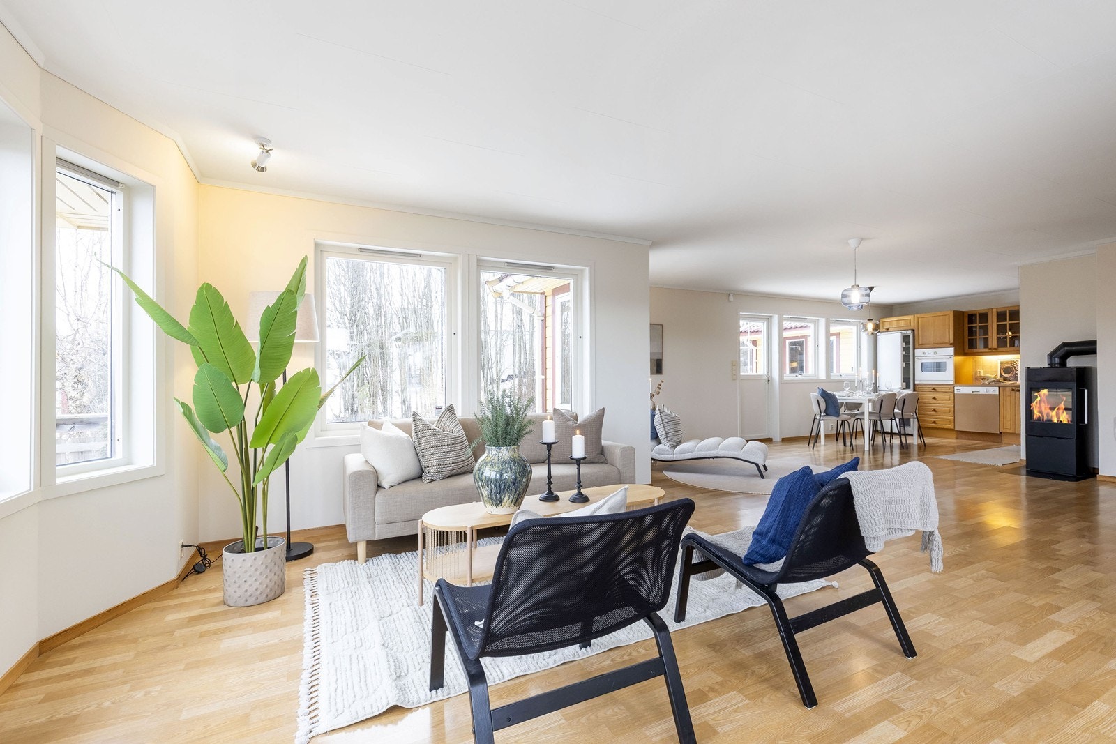 Stue med åpen kjøkkenløsning og peisovn Galleribilde