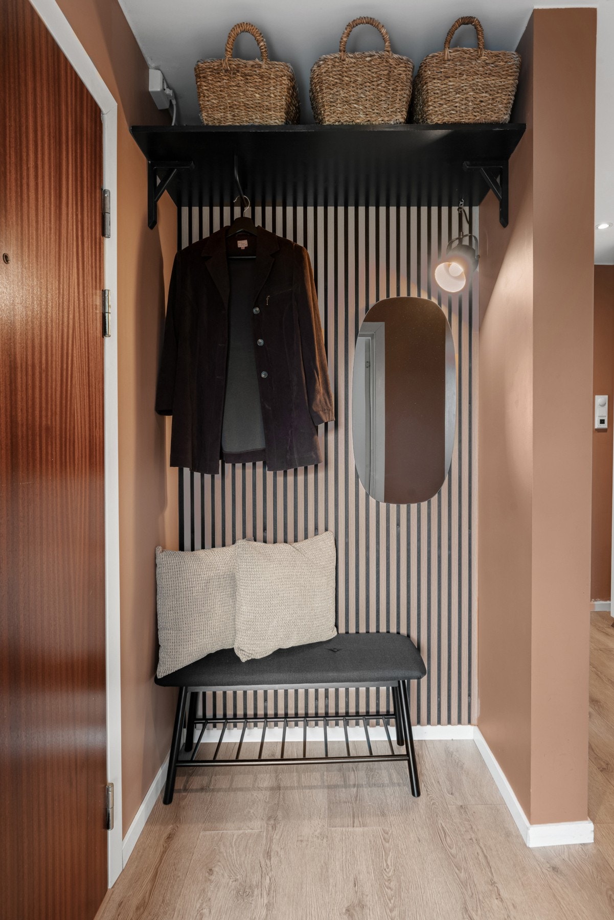 Entreen har egen garderobenisje med trendy spilevegg fra 2024 og sort hylle med oppheng. Galleribilde