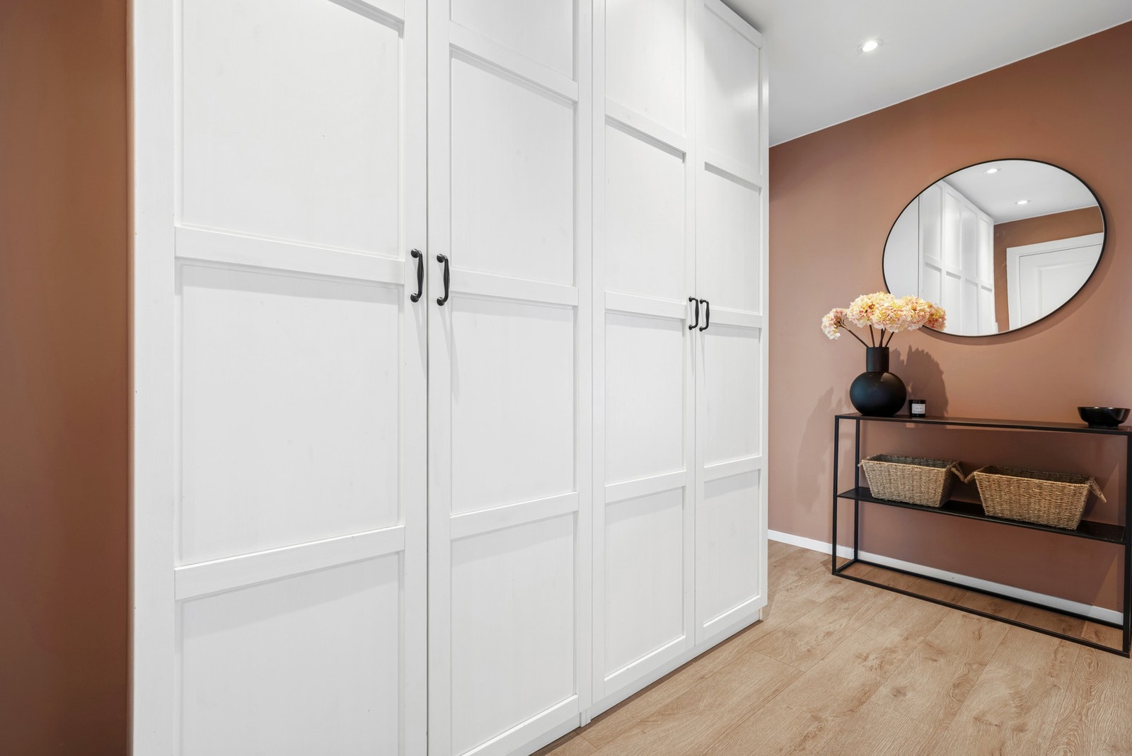 Entreen er av god størrelse og yttertøyet ryddes enkelt bort i et stort garderobeskap med hvite profilerte fronter. Galleribilde