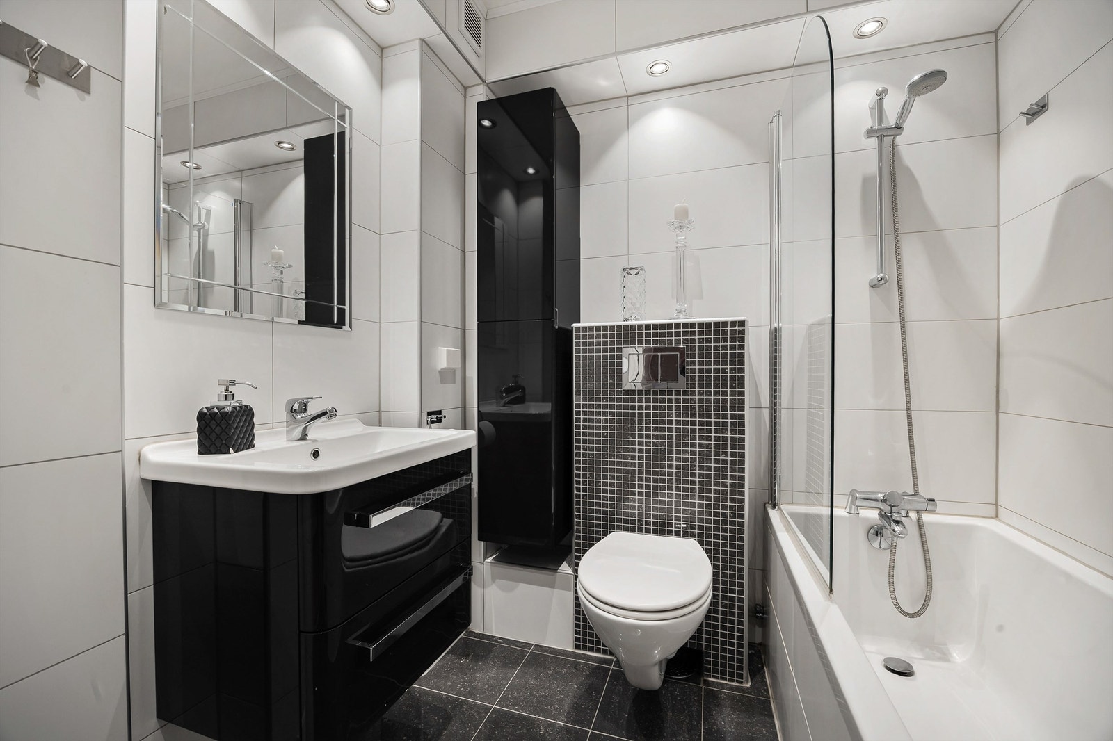 Baderomsinnredning i sort høyglans og downlights i taket gir et helhetlig inntrykk. Galleribilde