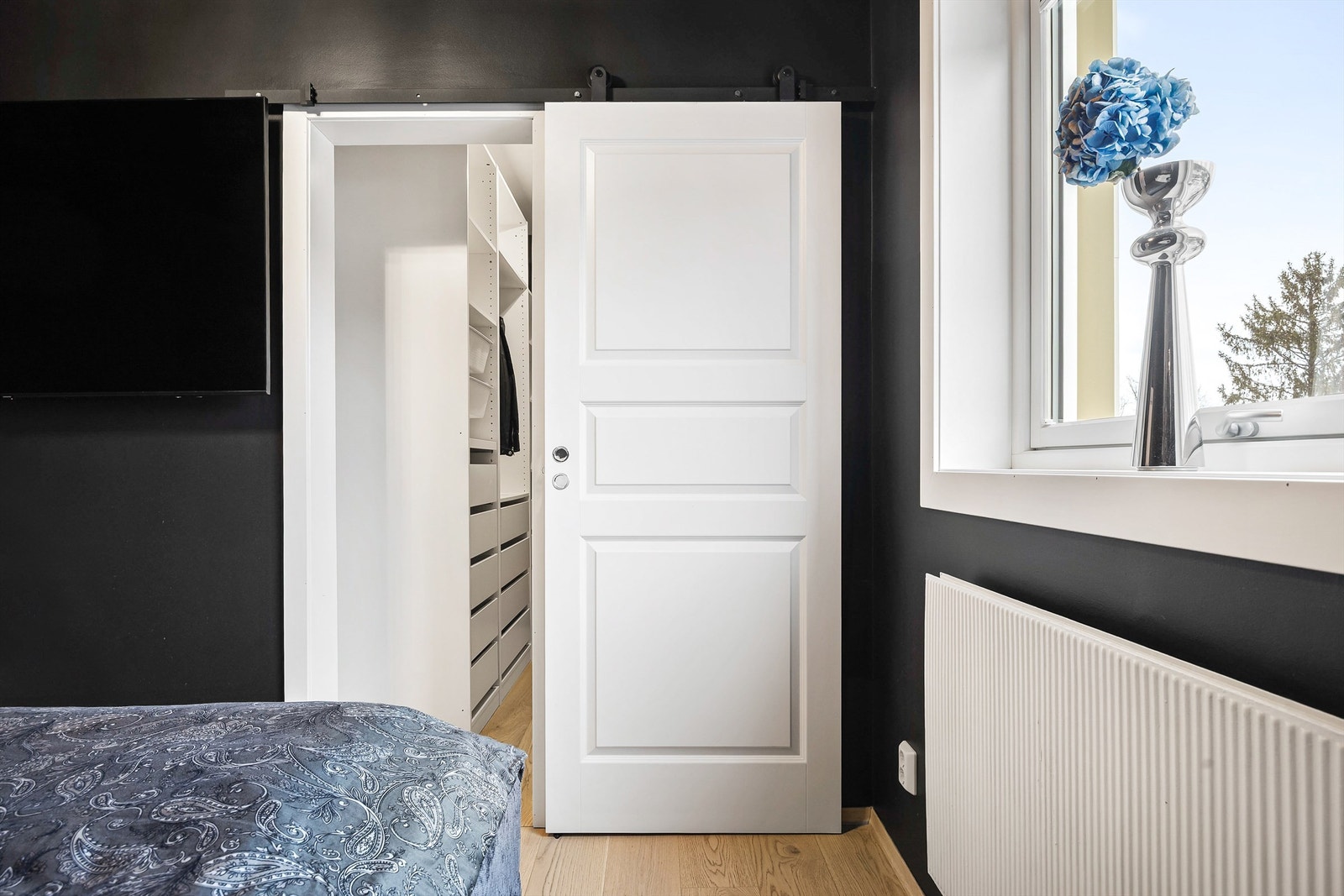 En plassbesparende skyvedør leder inn til et praktisk garderoberom. Galleribilde