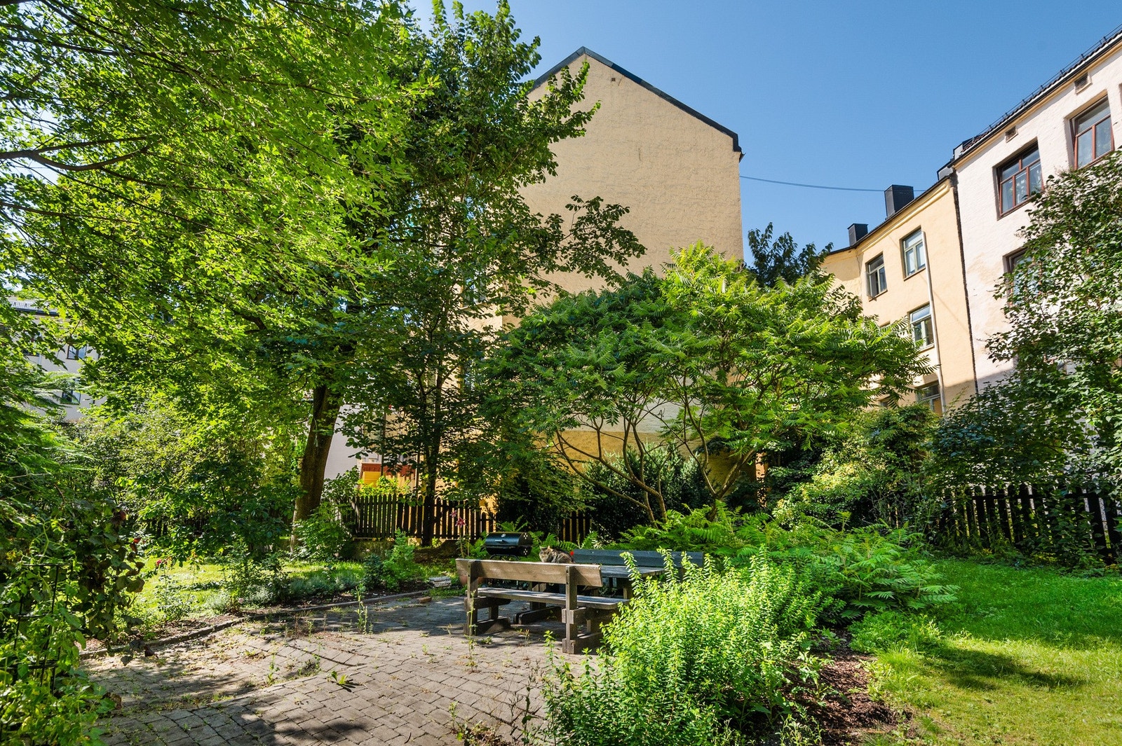 Bakgården er pent opparbeidet med sittebenker, gressplen, beplantning og grill. Galleribilde