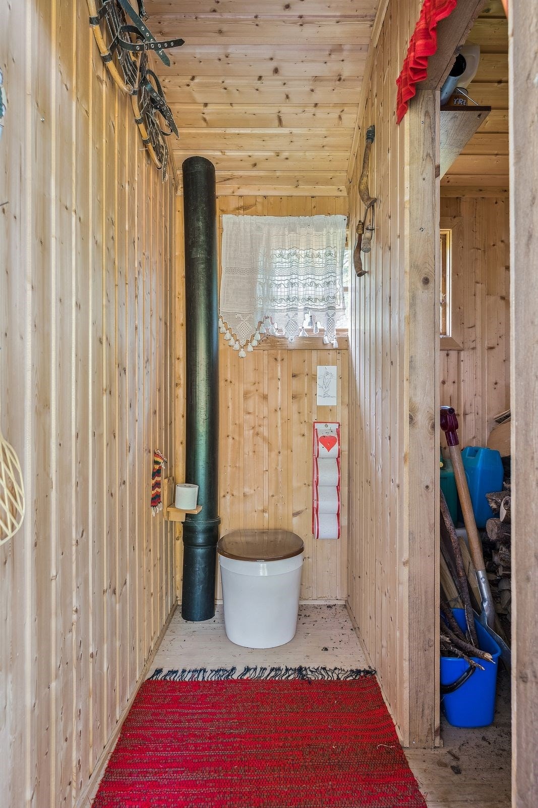 Bod med bio-do med toalettstol og avfallsbeholder på terreng under gulv. Galleribilde