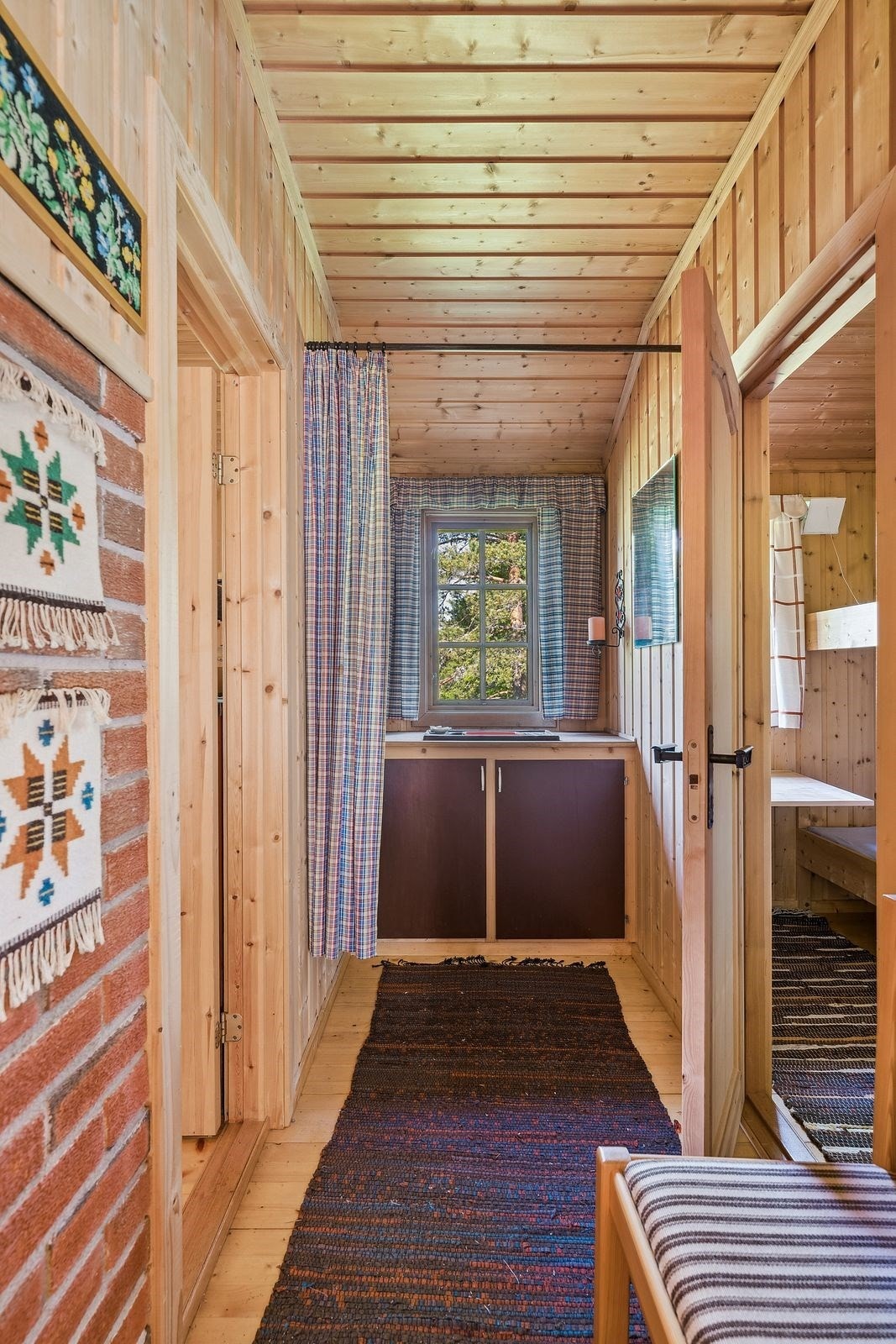 I hyttens soveromsgang finner man en vaskeplass. Benk med dører og nedfelt servant. Galleribilde