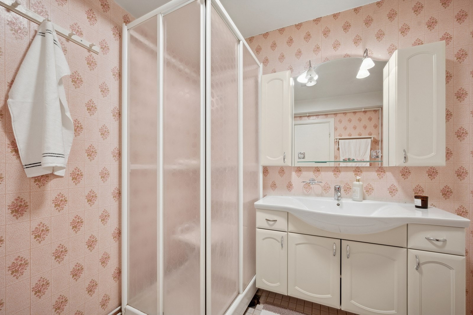 Badet er utstyrt med dusjkabinett og en lys baderomsinnredning med mye oppbevaringsplass. Galleribilde