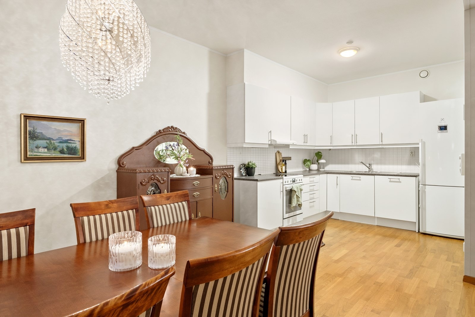 Kjøkkeninnredning med slette fronter i høyglans. Hvitevarer på kjøkken medfølger i handelen og er som følger: Frittstående kjøl/ fryseskap og komfyr, og integrert oppvaskmaskin. Galleribilde