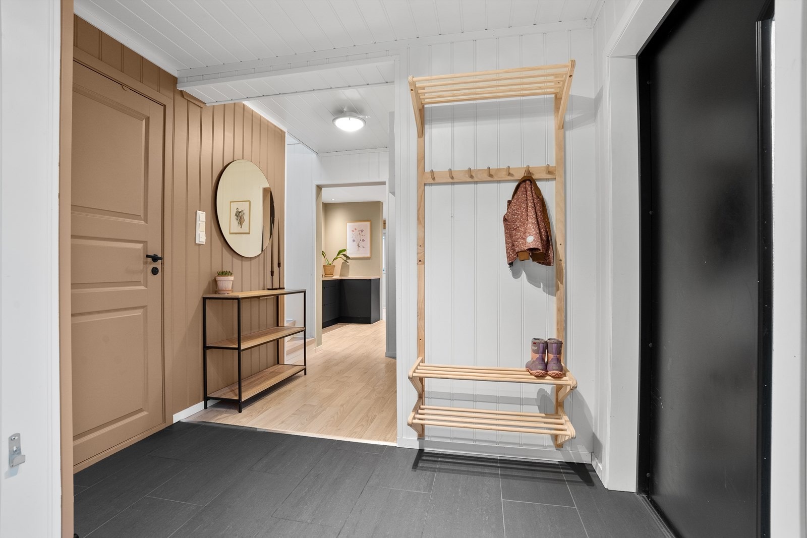 Legg merke til fargevalgene på veggene som gjør overgangen mellom rommene til ulike soner, slik at det er lett å se overgangen. Fra entreen er det dør til bad/vaskerom, og videre inn til kjøkken og stue/spisestue. Galleribilde