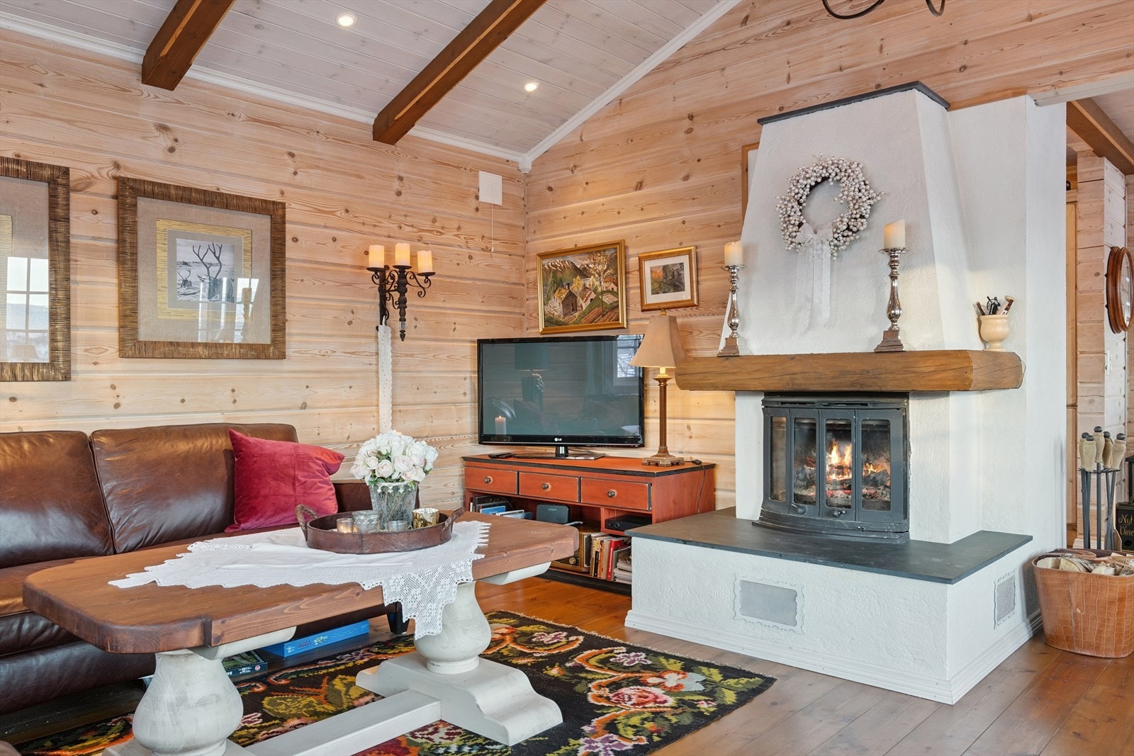 En pen, hvitmalt peis med innsats sørger for lun varme og en hyggelig stemning i rommet. Galleribilde