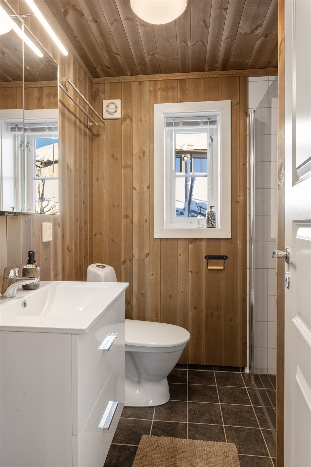 Badet er funksjonelt og praktisk med flislagt dusjnisje og gulv. Galleribilde