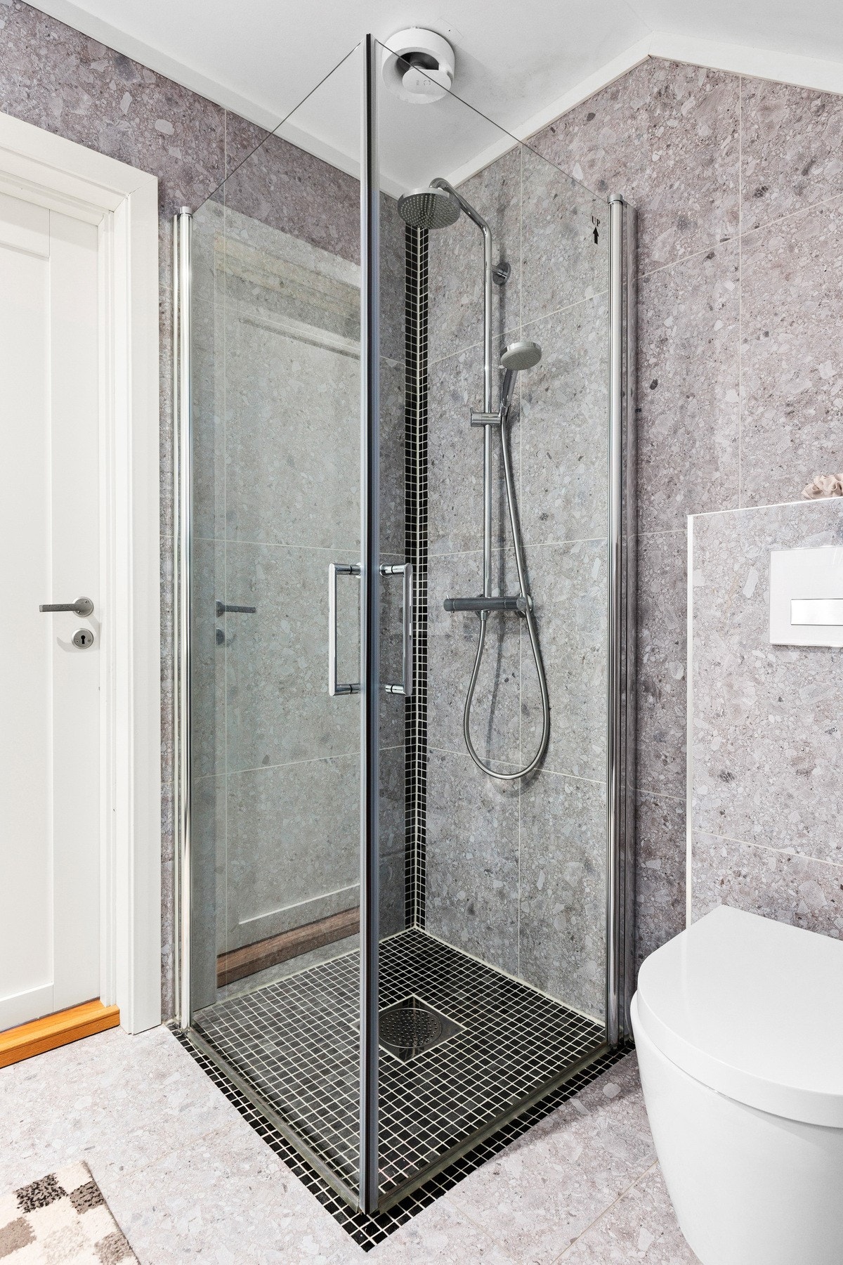 Badet har nedsenket dusjsone og innredning med vegghengt wc, dusjhjørne med takdusj/hånddusj og servantskap. Galleribilde