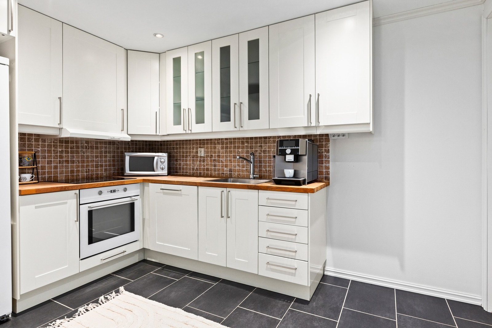 Kjøkkenet har IKEA-innredning med heltre benkeplate og fliser mellom over- og underskap. Galleribilde