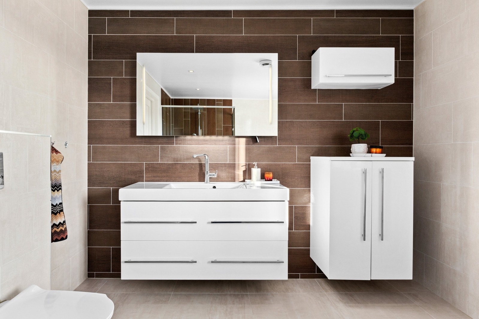 Rommet er innredet med vegghengt wc, stor dusjnisje med takdusj, servantskap, speil med lys, veggskap og frittstående badekar. Galleribilde