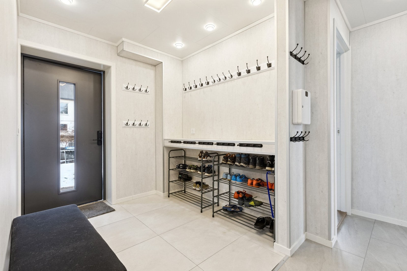 Gangen er innbydende med lyse fliser på gulv og matchende plater på vegg. Galleribilde