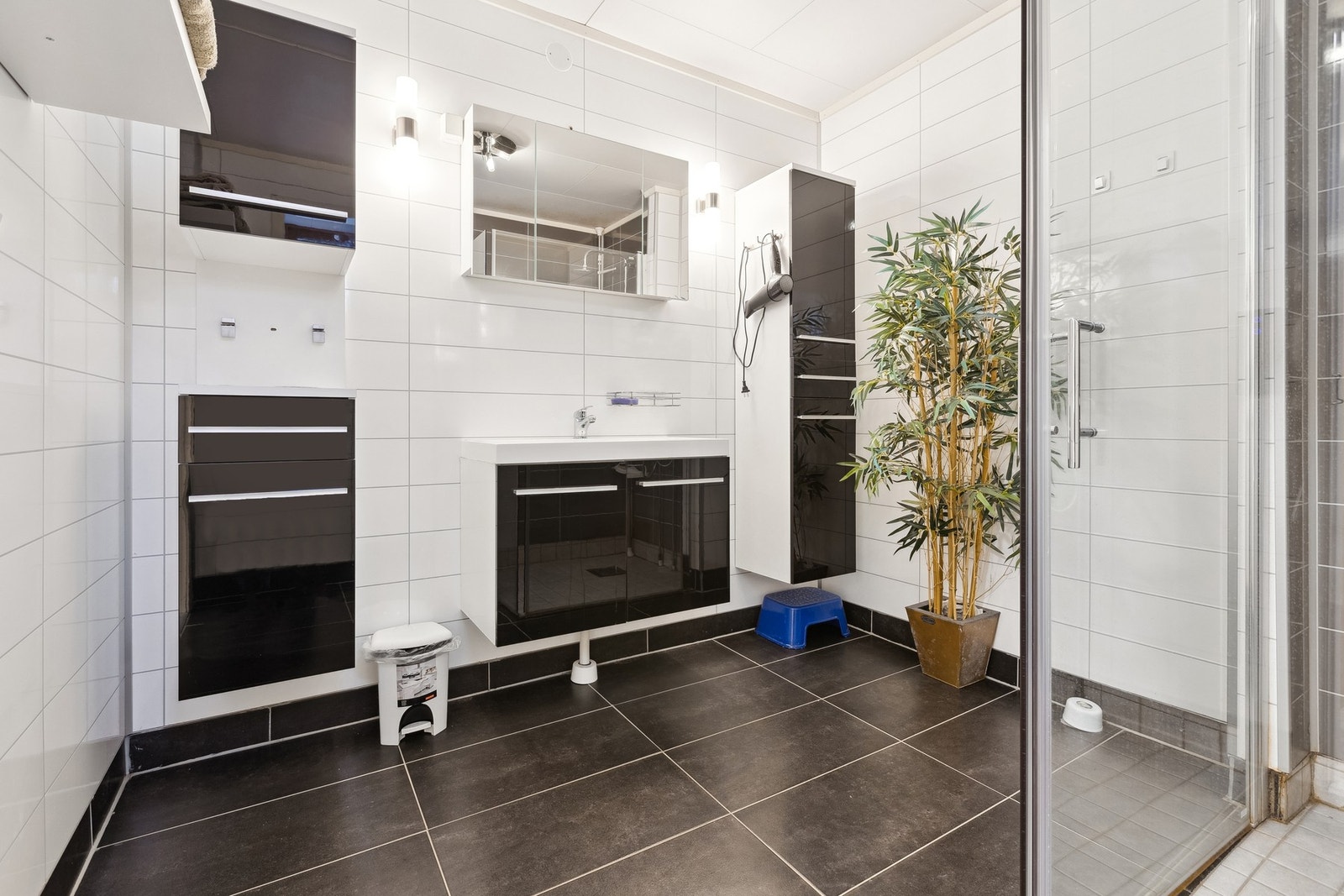 Pent bad med nyere innredning, fliser på gulv og moderne baderomsplater på vegg. Galleribilde