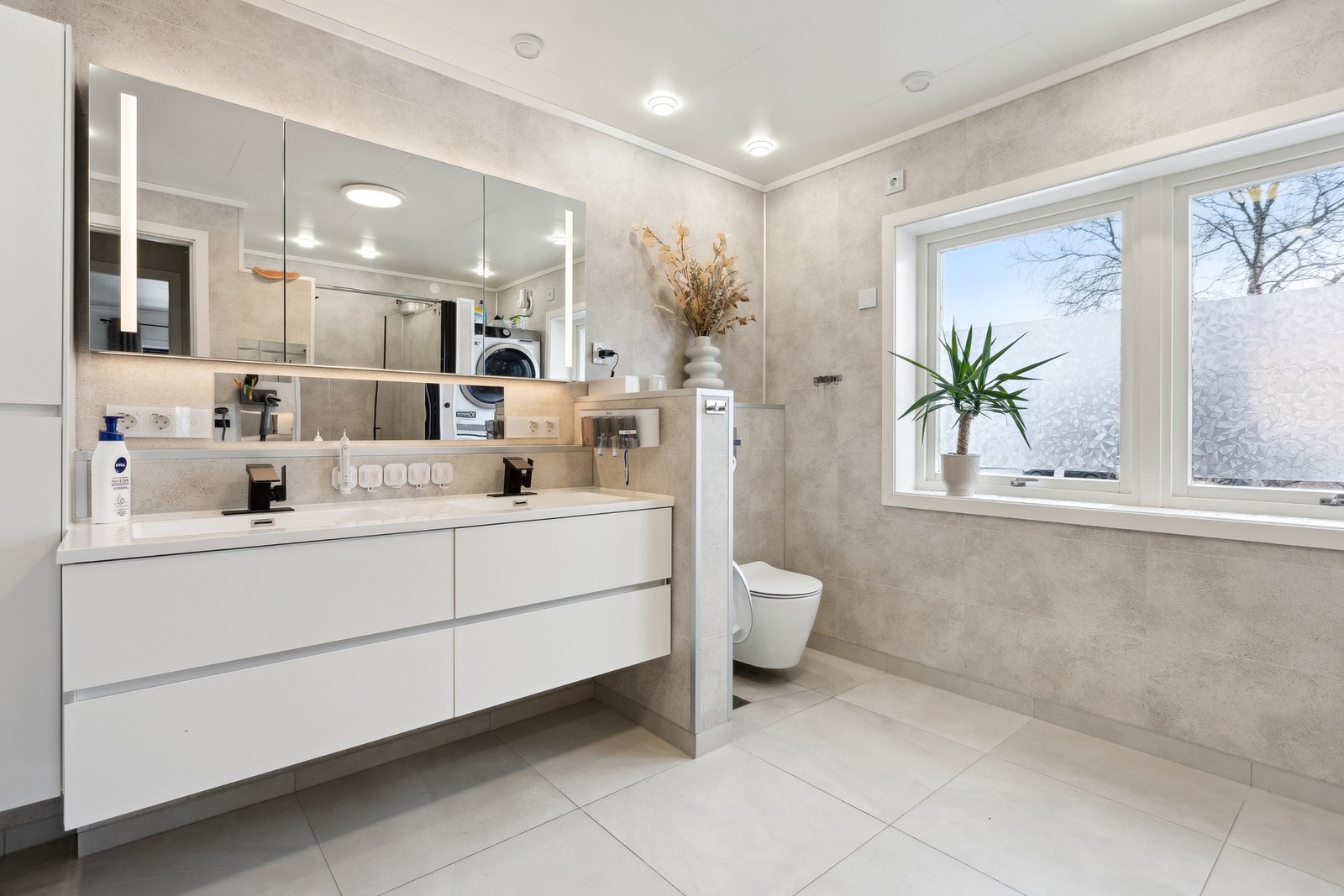 Badet er av nyere dato og er moderne innredet. Dobbel vask med moderne blandebatterier, store speilflater og vegghengt toalett. Galleribilde